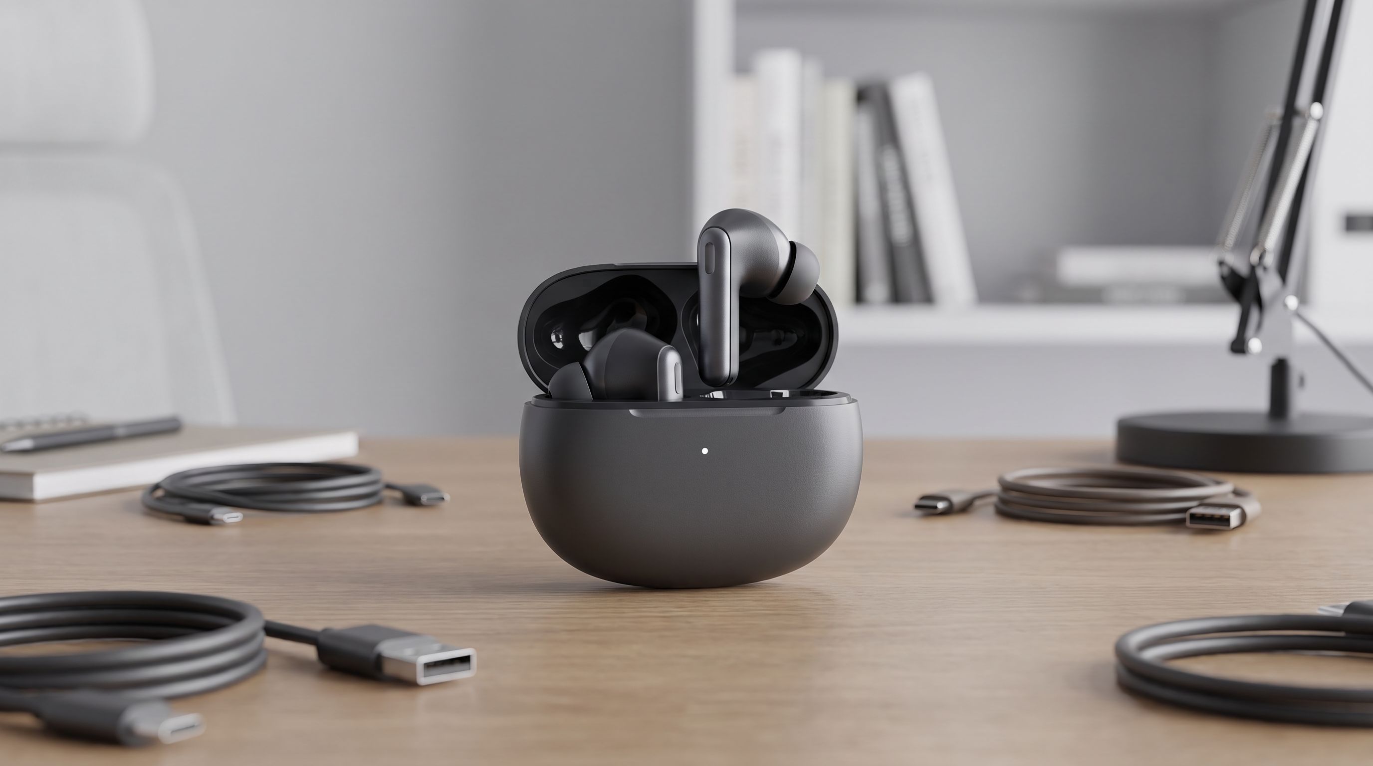 A set of wireless earbuds resting in their charging case on a desk